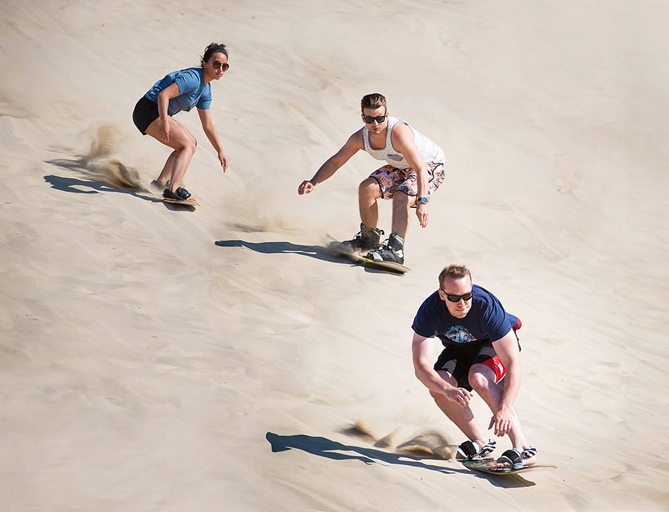 Sandboarding to zjazdy na desce po stromych, piaszczystych wydmach — to fajna wakacyjna atrakcja, którą bierze się przy okazji, kiedy los rzuci Cię w okolice dużych wydm.